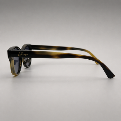 Olivencia ALAIS · EQUINOX handcrafted black and white horn sunglasses in side profile with gradient brown lenses.