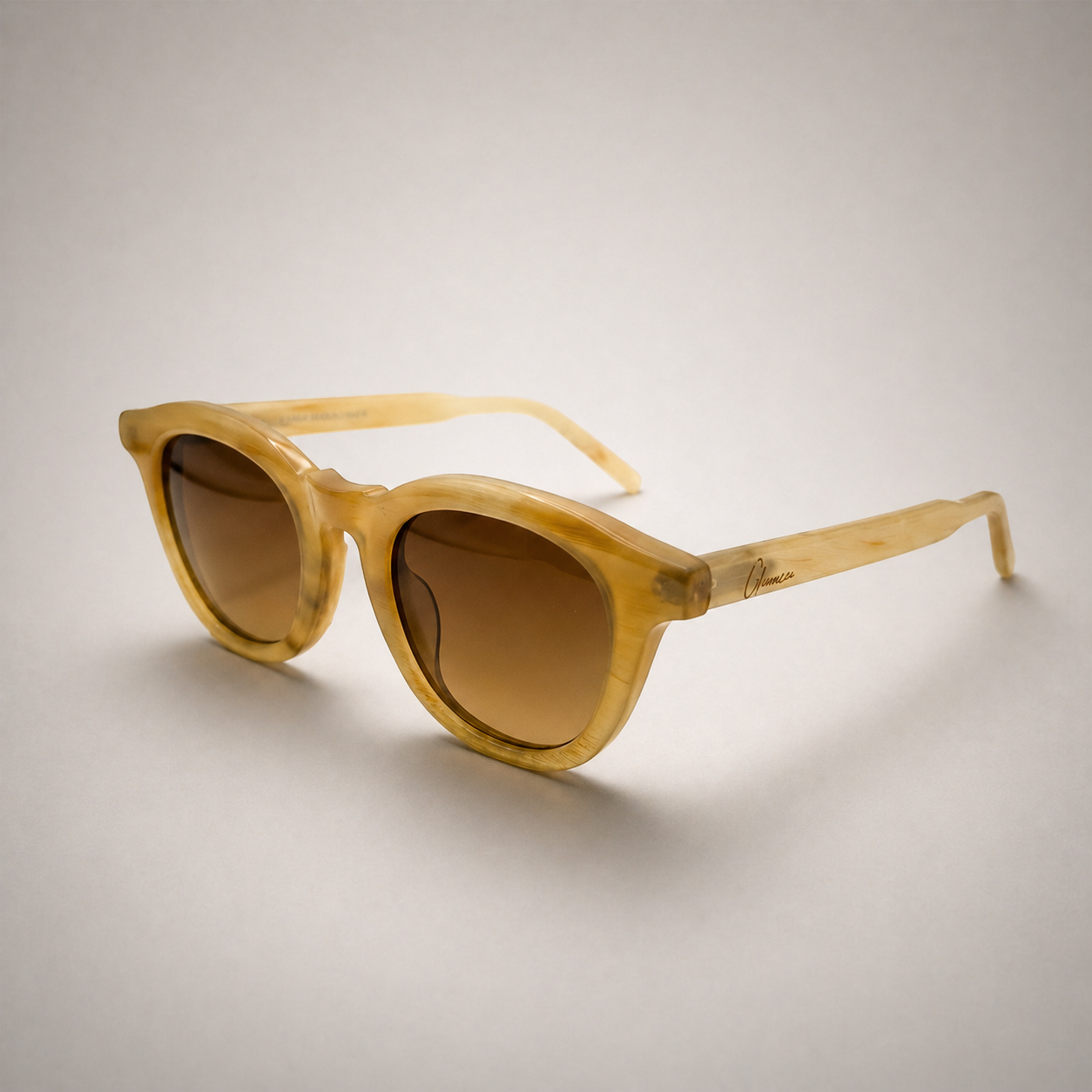 Olivencia AVELINE MIEL handcrafted honey horn sunglasses in angled view with gradient brown lenses.