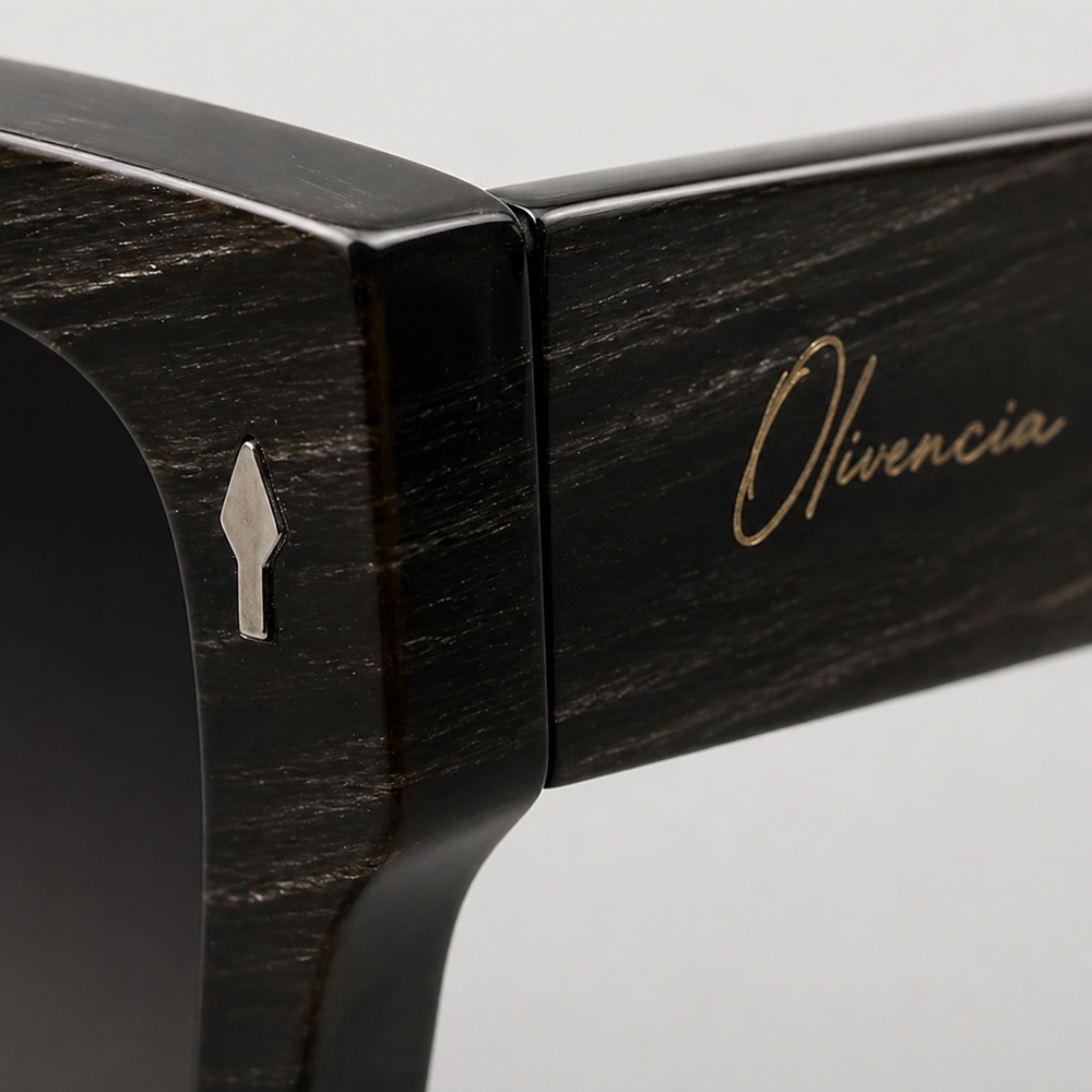 Close-up of Olivencia ORIAN · LINEA handcrafted black horn sunglasses, showing the rare natural white-line pattern and gradient black lenses.