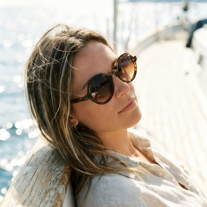 Woman wearing Olivencia SOREL · VIREO handcrafted dark green-black buffalo horn sunglasses with gradient brown lenses and a rounded oval silhouette.